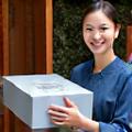 丁寧に梱包された金属作品を顧客へ届ける様子
